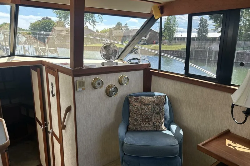 Slide: The Image of 1985 Carver 3207 Aft Cabin interior with chair, windows, and nautical decor. - 26