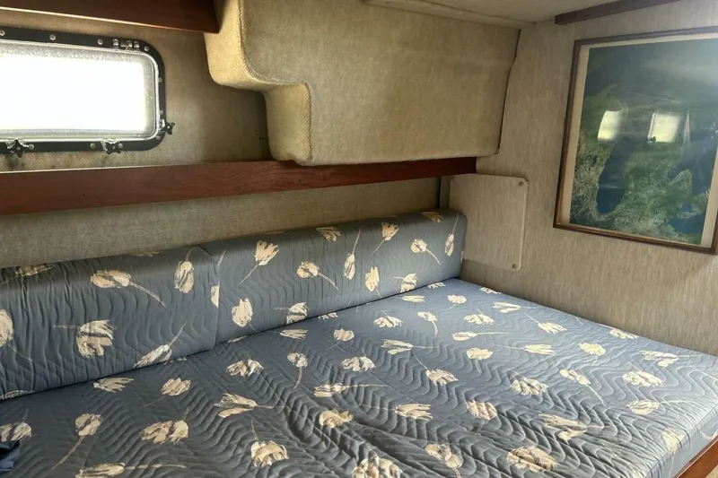 Slide: The Image of 1985 Carver 3207 Aft Cabin interior with floral-patterned bedding and wall art. - 7