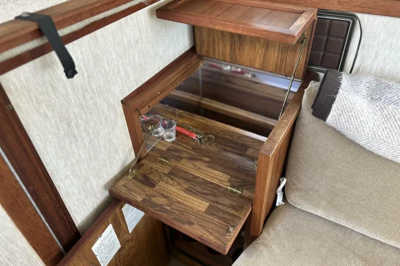 Slide: The Image of 1985 Carver 3207 Aft Cabin interior with wooden fold-out table and beige seating. - 18