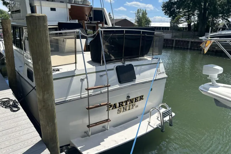 Slide: The Image of 1985 Carver 3207 Aft Cabin boat docked, featuring "PARTNER SHIP II" name on stern. - 3