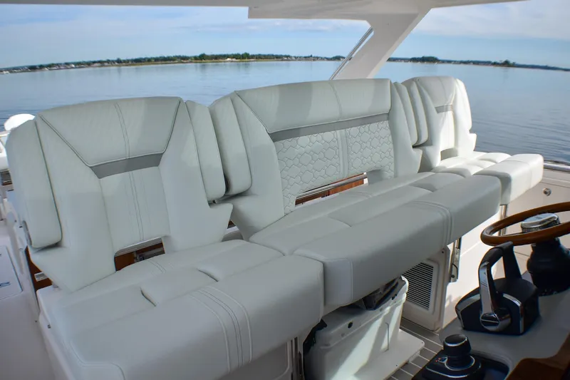 Slide: The Image of 2025 Tiara Yachts 43 LS interior with luxurious white seating and helm, overlooking serene waters. - 16
