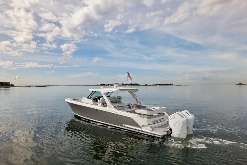 Slide: The Image of 2025 Tiara Yachts 43 LS cruising on calm waters under a partly cloudy sky. - 2