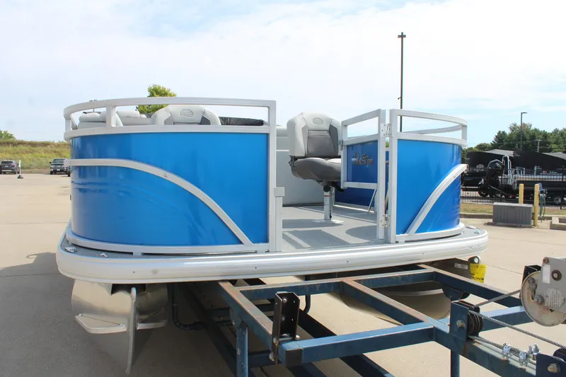 Slide: The Image of 2026 Sun Tracker Fishin' Barge 20 DLX pontoon boat on trailer, blue exterior. - 2