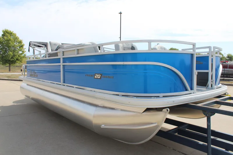Slide: The Image of 2026 Sun Tracker Fishin' Barge 20 DLX pontoon boat, blue exterior, docked on trailer. - 3