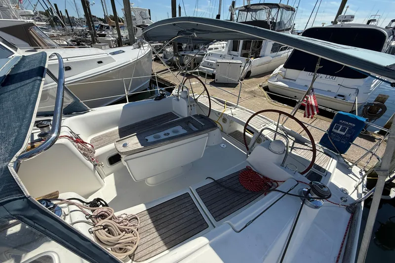 Slide: The Image of 2010 Beneteau Oceanis 43 sailboat cockpit with dual steering wheels, docked at marina. - 11