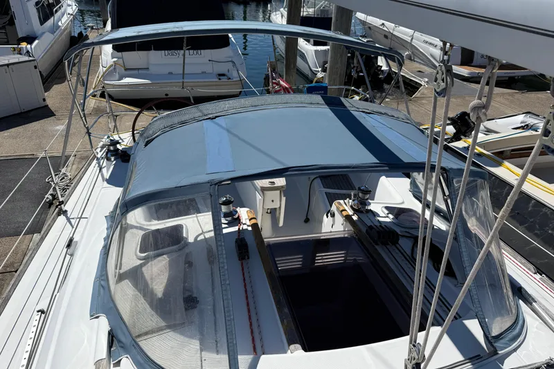 Slide: The Image of 2010 Beneteau Oceanis 43 sailboat docked, featuring a covered cockpit and visible winches. - 4