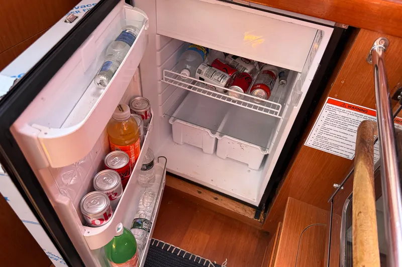 Slide: The Image of Open fridge on 2010 Beneteau Oceanis 43 yacht, stocked with drinks and beverages. - 40