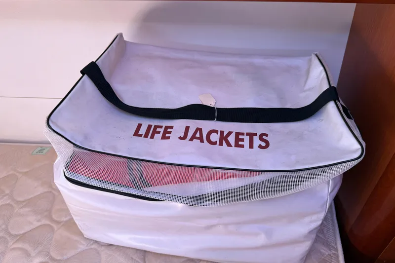 Slide: The Image of Life jackets stored in a white bag on a Beneteau Oceanis 43, 2010 model. - 77