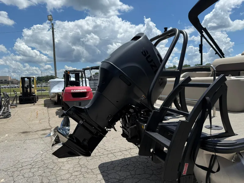 Slide: The Image of 2026 Bentley Pontoons Legacy 243 Swingback with Suzuki outboard motor, parked outdoors under cloudy sky. - 14