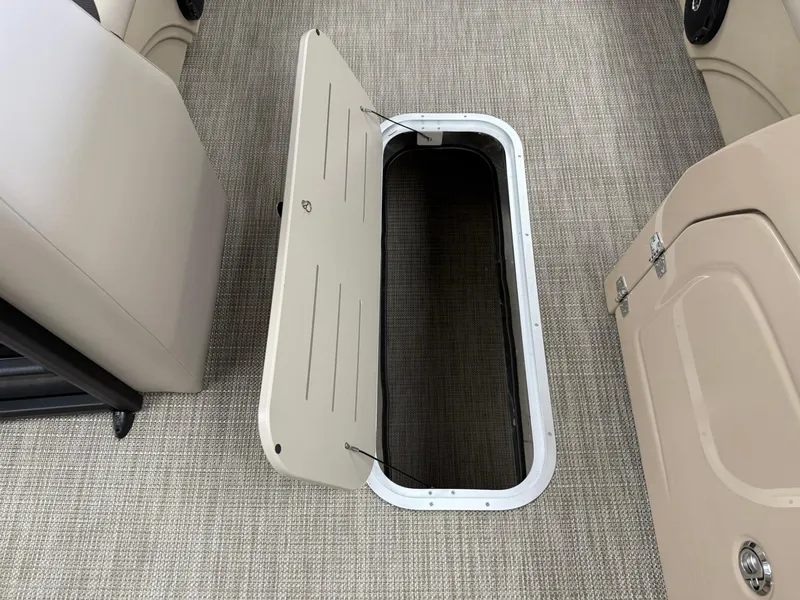 Slide: The Image of 2026 Bentley Pontoons Legacy 243 Navigator storage compartment with open hatch on carpeted floor. - 4