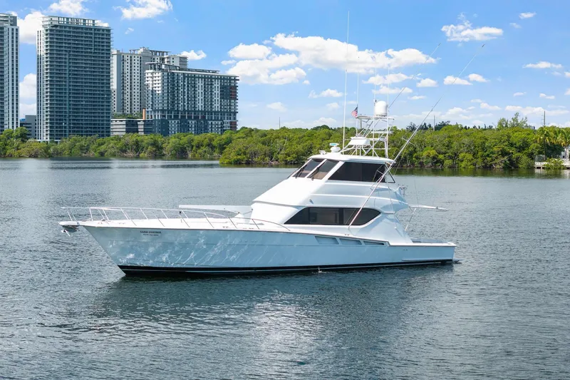 Slide: The Image of 2002 Hatteras 60 Convertible yacht on water with city skyline background. - 11