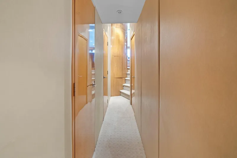 Slide: The Image of Interior hallway of 2002 Hatteras 60 Convertible yacht with wooden doors and carpeted floor. - 16