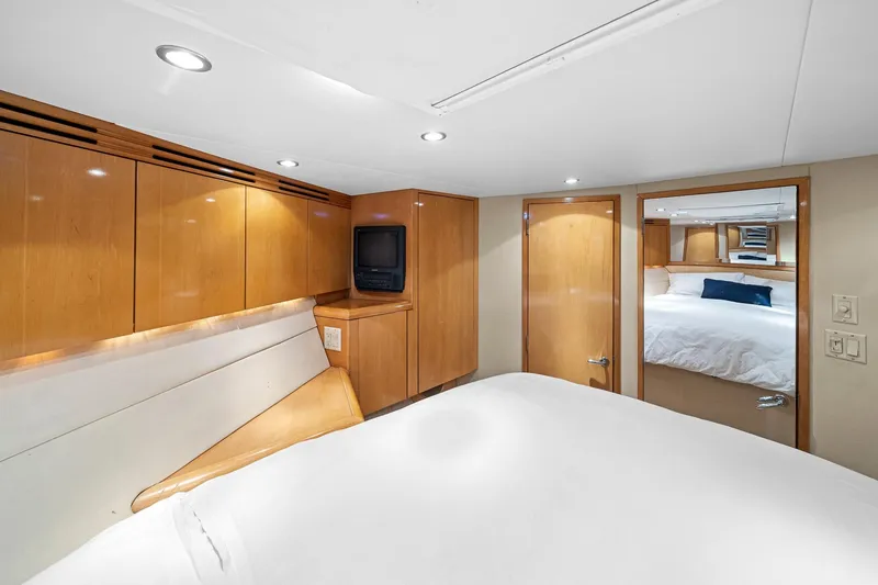 Slide: The Image of Luxurious cabin interior of 2002 Hatteras 60 Convertible yacht with wood paneling and cozy bed. - 17