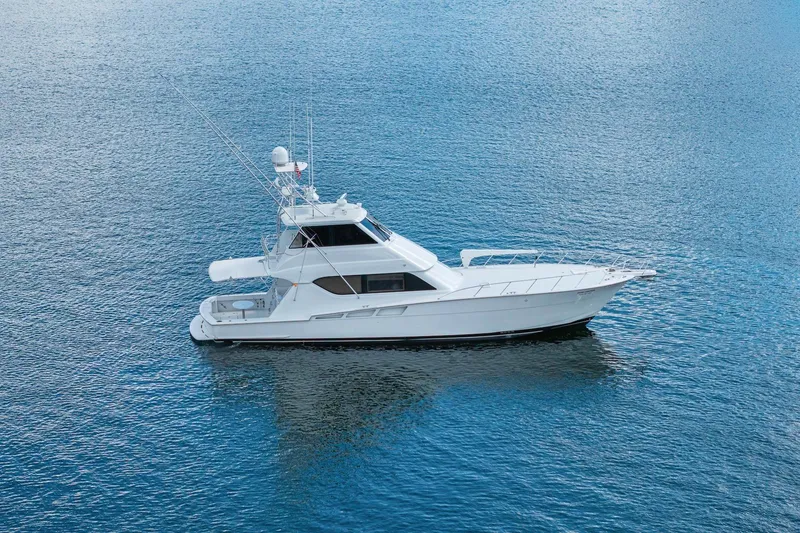 Slide: The Image of 2002 Hatteras 60 Convertible yacht on calm blue water. - 2