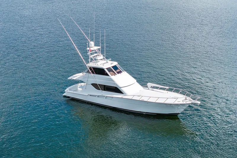 Slide: The Image of 2002 Hatteras 60 Convertible yacht on calm blue water. - 3