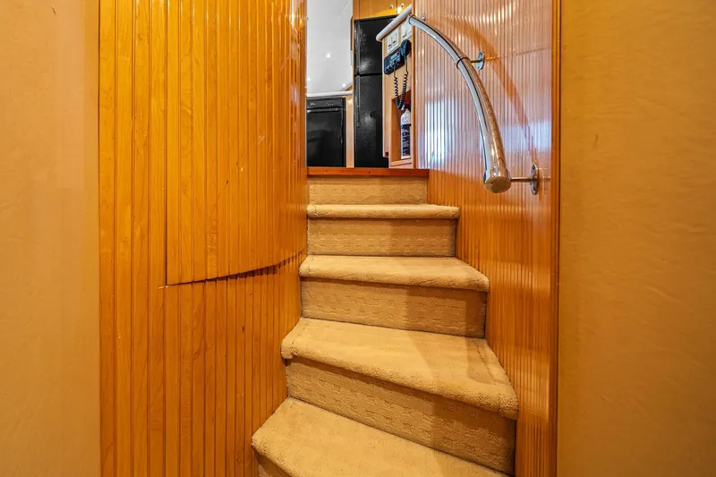 Slide: The Image of Interior staircase of 2002 Hatteras 60 Convertible yacht with wooden paneling and carpeted steps. - 39