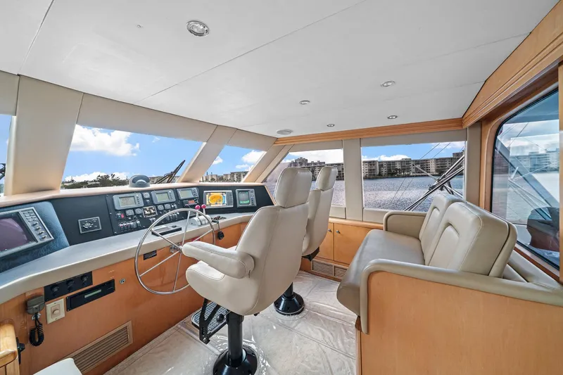 Slide: The Image of Luxurious helm of 2002 Hatteras 60 Convertible yacht with panoramic windows and modern controls. - 42