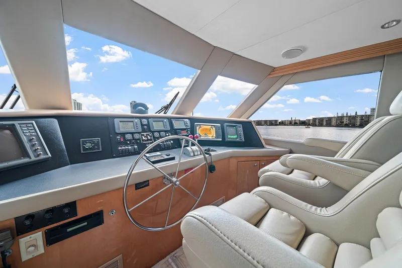 Slide: The Image of Helm of 2002 Hatteras 60 Convertible yacht with modern navigation equipment and plush seating. - 49