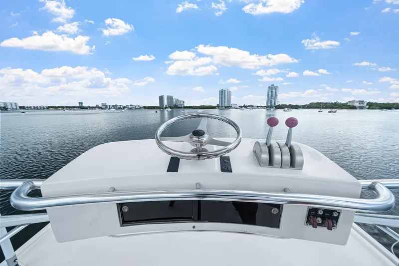 Slide: The Image of Helm of 2002 Hatteras 60 Convertible yacht with city skyline view. - 50