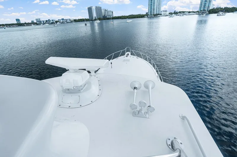 Slide: The Image of Bow view of 2002 Hatteras 60 Convertible yacht on calm water with city skyline. - 51