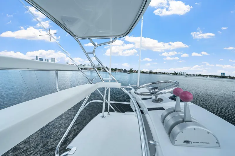 Slide: The Image of 2002 Hatteras 60 Convertible yacht helm with ocean view and city skyline. - 52