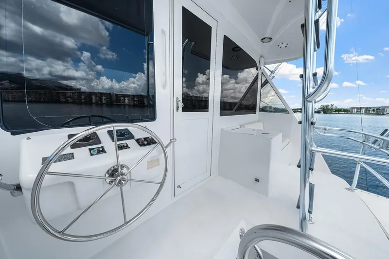 Slide: The Image of 2002 Hatteras 60 Convertible yacht helm with steering wheel and ocean view. - 56