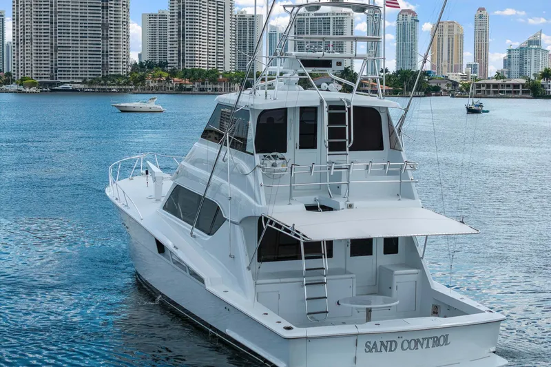 Slide: The Image of 2002 Hatteras 60 Convertible yacht on water with city skyline background. - 6