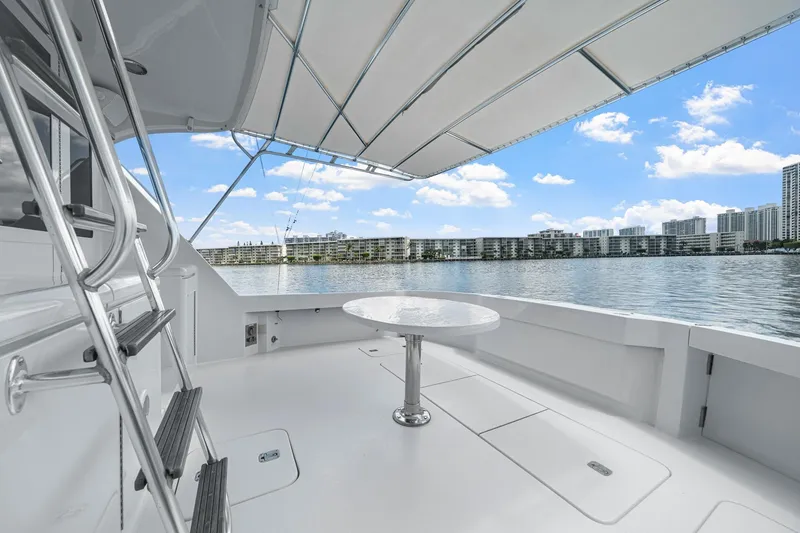 Slide: The Image of 2002 Hatteras 60 Convertible yacht deck with awning, overlooking waterfront skyline. - 61