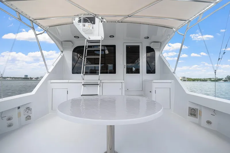 Slide: The Image of 2002 Hatteras 60 Convertible yacht deck with table, ladder, and ocean view. - 63