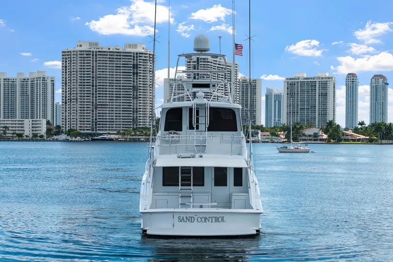 Slide: The Image of 2002 Hatteras 60 Convertible yacht on water, city skyline in background. - 7