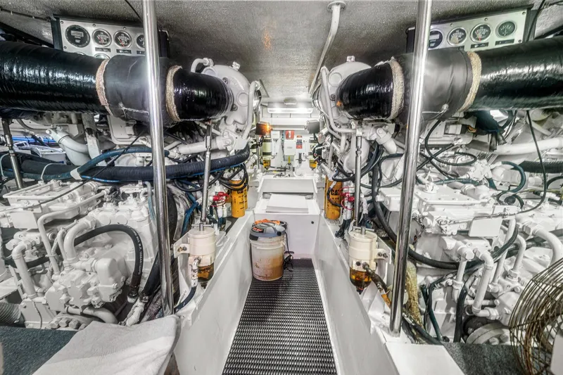 Slide: The Image of Engine room of a 2002 Hatteras 60 Convertible yacht, showcasing machinery and equipment. - 73