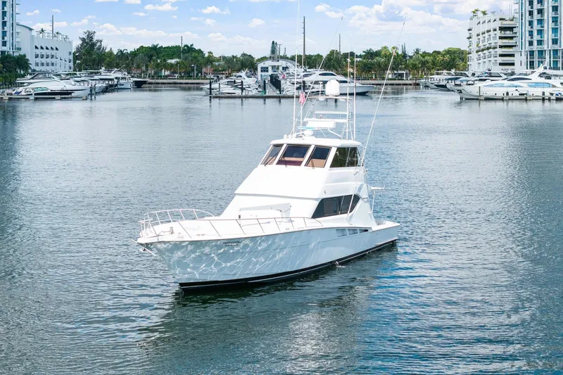 Slide: The Image of 2002 Hatteras 60 Convertible yacht docked in a marina with surrounding boats. - 9
