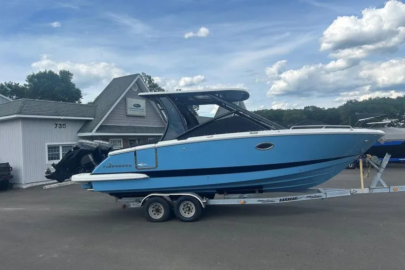 Slide: The Image of 2026 Chaparral 280 OSX boat on trailer, parked outside dealership under blue sky. - 12