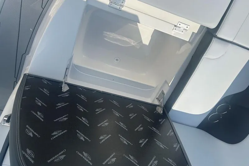 Slide: The Image of Open storage compartment on 2026 Chaparral 280 OSX boat, featuring branded interior mat. - 26