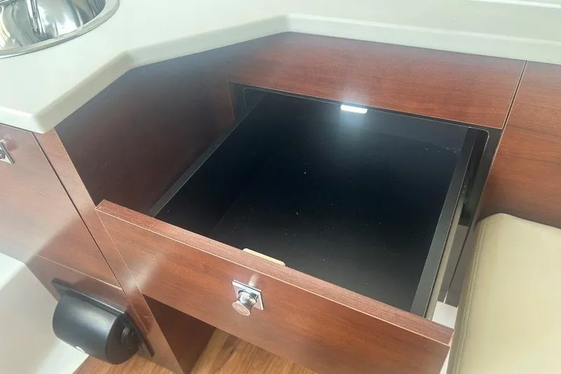 Slide: The Image of Open drawer in Chaparral 280 OSX 2026 boat interior, featuring wood finish and sink. - 32