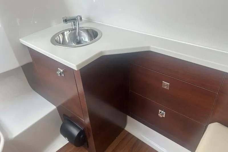 Slide: The Image of Interior of 2026 Chaparral 280 OSX boat featuring a sleek sink and wooden cabinetry. - 35
