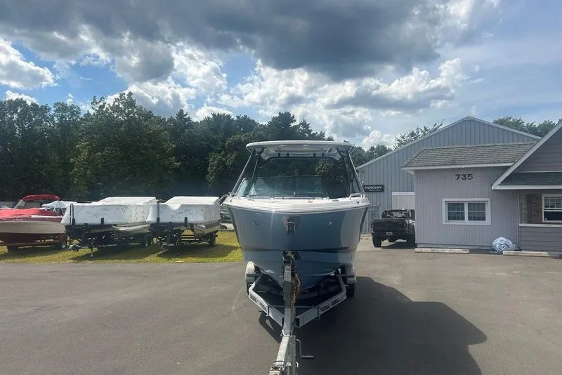 Slide: The Image of 2026 Chaparral 280 OSX boat on trailer, parked outside dealership under cloudy sky. - 4