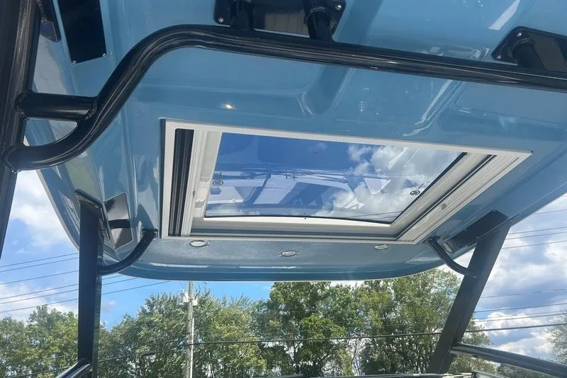 Slide: The Image of 2026 Chaparral 280 OSX boat roof with skylight, showcasing blue exterior and sturdy frame. - 40
