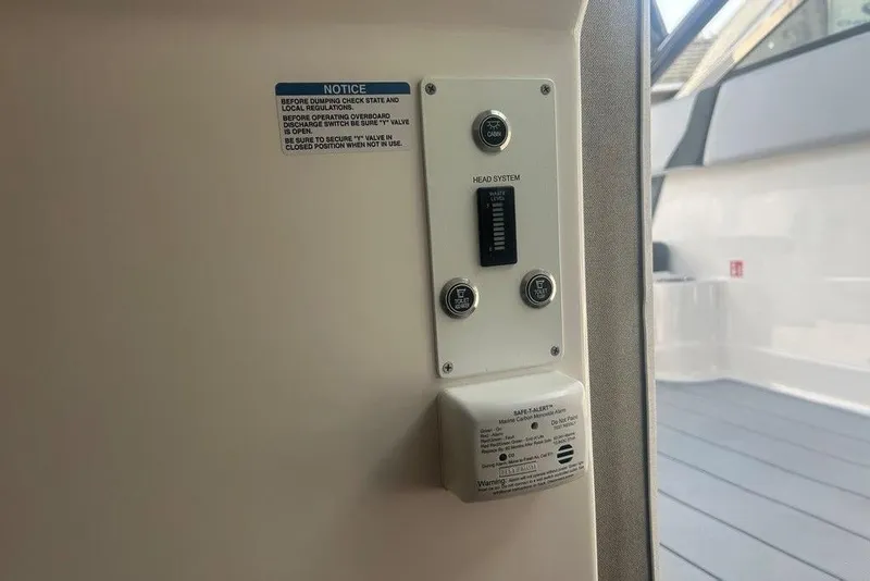 Slide: The Image of Control panel on 2026 Chaparral 280 OSX boat, featuring head system and safety notice. - 43