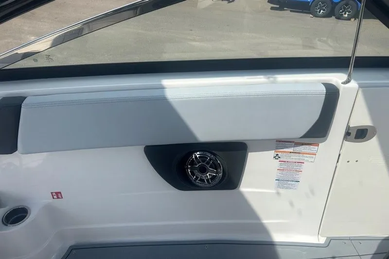 Slide: The Image of Interior view of 2026 Chaparral 280 OSX boat, featuring speaker and safety labels. - 54