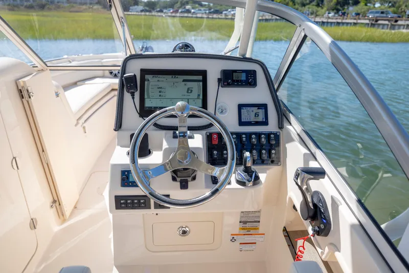 Slide: The Image of 2023 Grady-White Freedom 235 boat cockpit with steering wheel and control panel. - 10