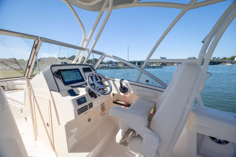Slide: The Image of 2023 Grady-White Freedom 235 boat interior with modern helm and waterfront view. - 11