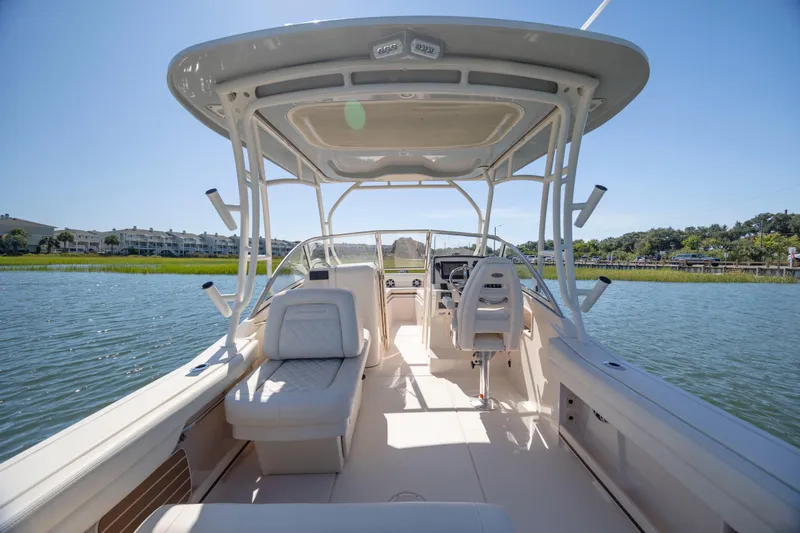 Slide: The Image of 2023 Grady-White Freedom 235 boat interior on calm water, showcasing seating and helm. - 14
