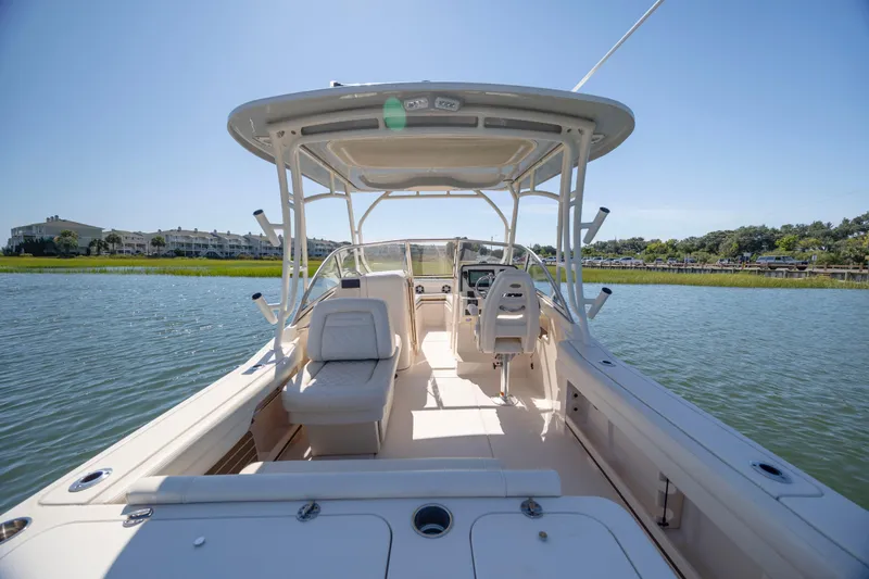 Slide: The Image of 2023 Grady-White Freedom 235 boat interior on calm water, showcasing seating and helm. - 15