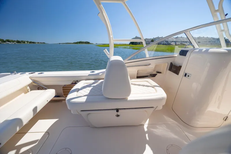 Slide: The Image of 2023 Grady-White Freedom 235 boat interior with seating, on a sunny day by the water. - 16