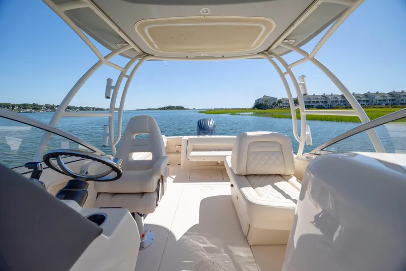 Slide: The Image of 2023 Grady-White Freedom 235 boat interior with steering wheel, seats, and scenic water view. - 17