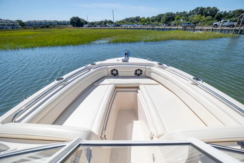Slide: The Image of 2023 Grady-White Freedom 235 boat interior with white seating on calm water. - 19