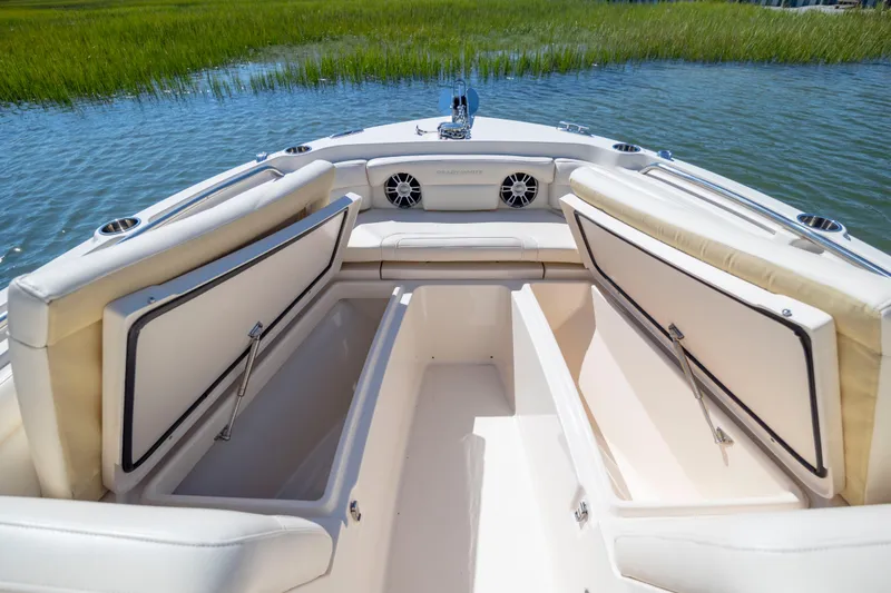 Slide: The Image of 2023 Grady-White Freedom 235 boat interior with open storage compartments on a sunny day. - 20