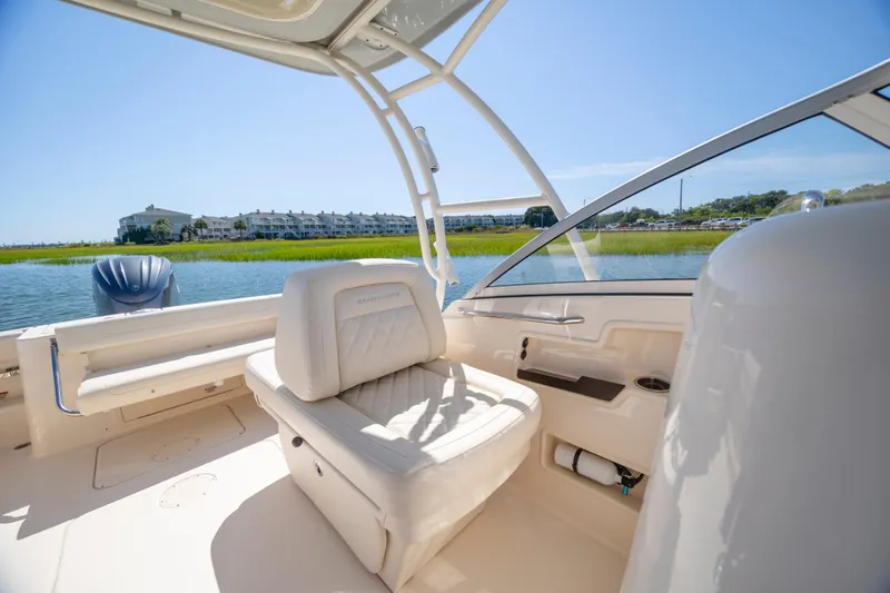 Slide: The Image of 2023 Grady-White Freedom 235 boat interior with luxurious seating and scenic waterfront view. - 22