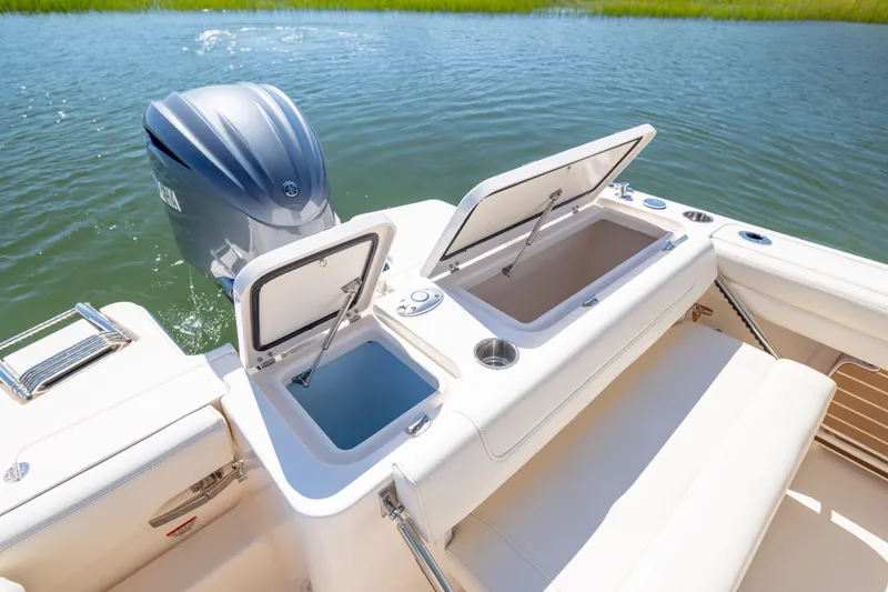 Slide: The Image of 2023 Grady-White Freedom 235 boat with open storage compartments and outboard motor. - 25